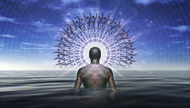 Muž s výrazným tetovaním na chrbte kráča vo vode.jpg
